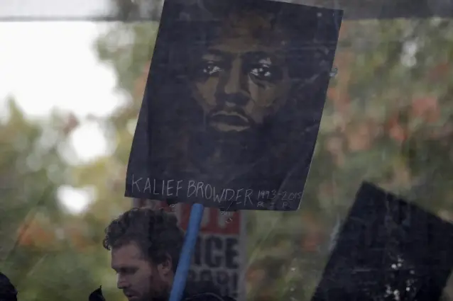A protester holds a picture Kalief Browder, who spent three of his late teen years imprisoned on Rikers Island waiting to be tried for a petty robbery charge that was ultimately dismissed.